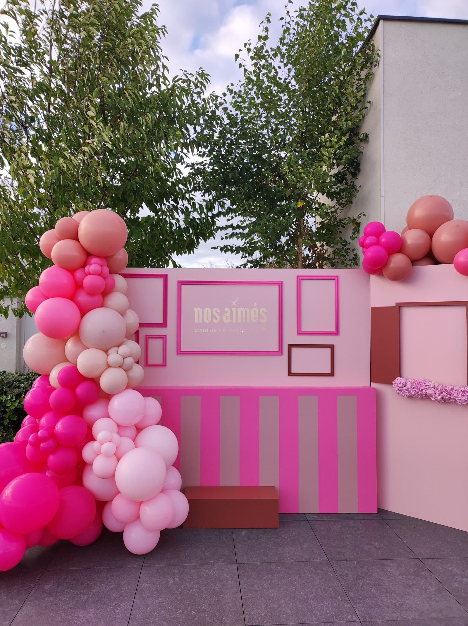 Lancement produit Nos Aimées avec backdrop modulable et arches de ballons sur rooftop