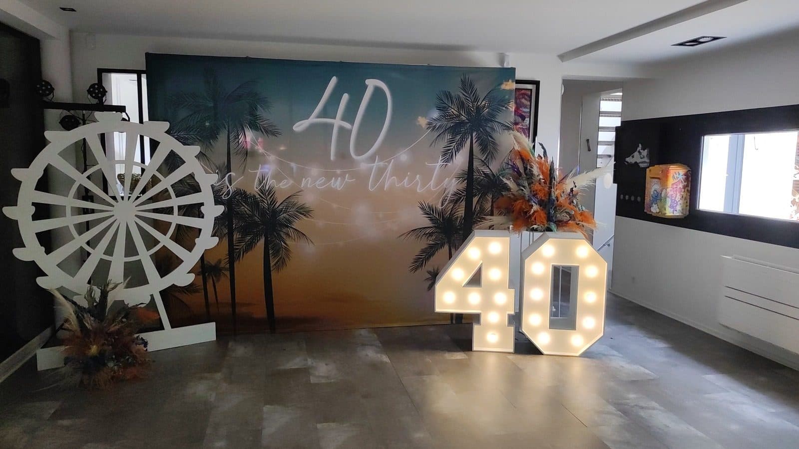 Décoration anniversaire 40 ans avec backdrop tropical et roue de festival