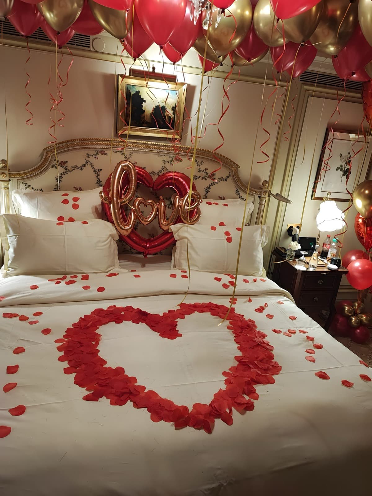 Décoration romantique suite Ritz Paris avec ballons cœur rouges et dorés pour demande en mariage
